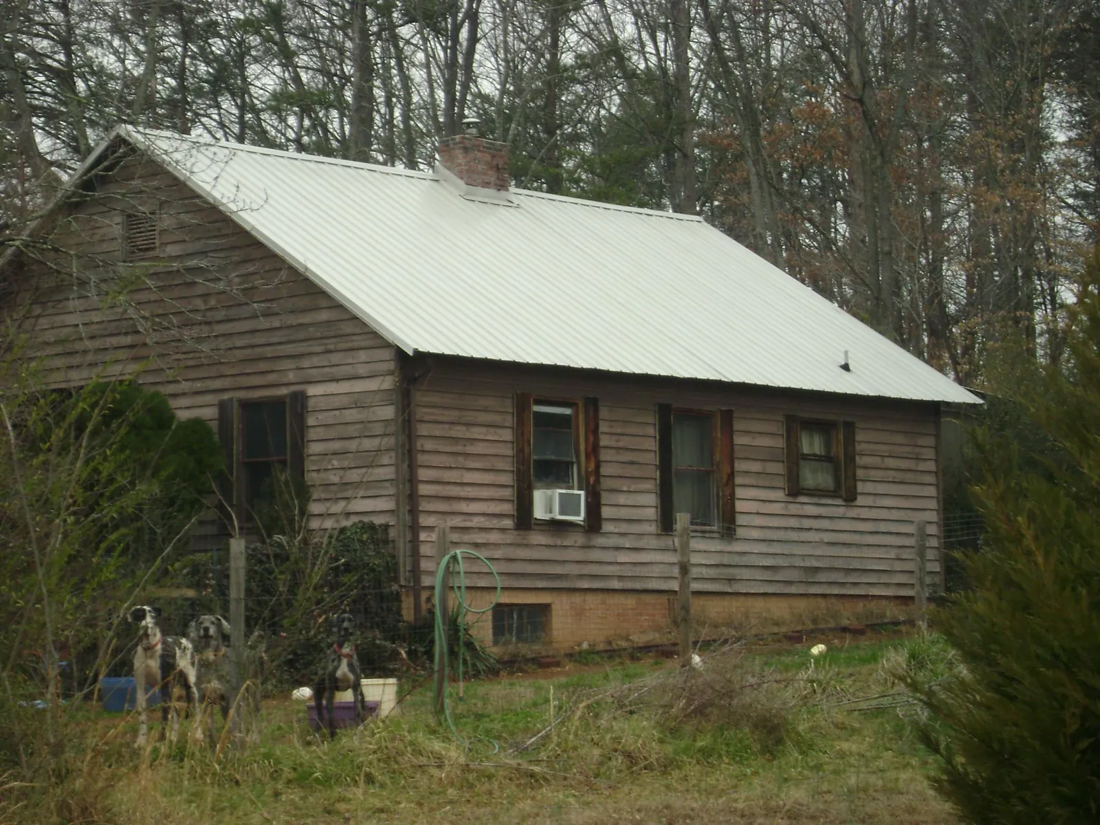 White metal roof on an old wood sided farmhouse, from a Metal Roof Installation job in Minburn